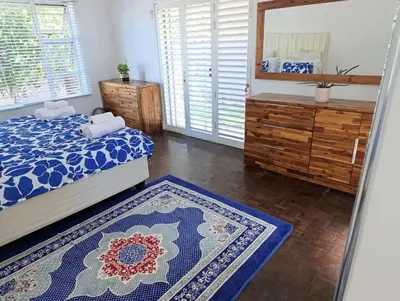 a bedroom with a bed and a mirror at Ascot manor in Cape Town