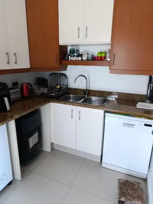 a kitchen with white cabinets and a sink at Ascot manor in Cape Town