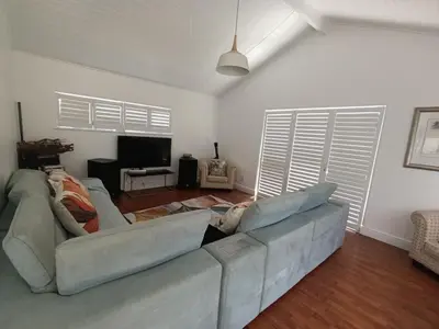 a living room with a couch and a television at Ascot manor in Cape Town