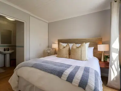 a bedroom with a bed with a blue and white blanket at Salt & Butter in Hermanus