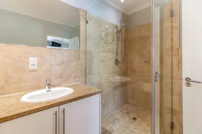 a bathroom with a sink and a shower at Luxury Lakeside Lodge at Jack Nicklaus Golf Estate in Simondium