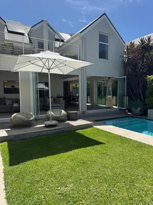 a house with an umbrella and a swimming pool at 9 Charme in Stellenbosch