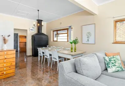 a living room with a couch and a table with chairs at Sea view holiday home in Kleinmond