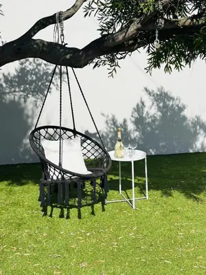 a swing chair and a table under a tree at Sea view holiday home in Kleinmond