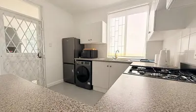 a kitchen with a black refrigerator and a stove at Crescent House in Franschhoek