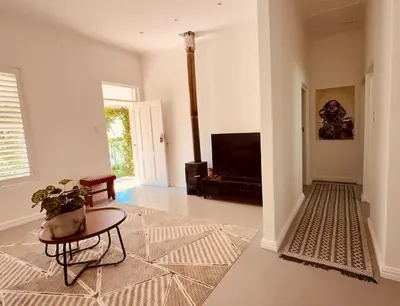 a living room with a table and a television at Crescent House in Franschhoek