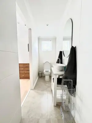 a white bathroom with a toilet and a sink at Mountain View Voëlklip One Bedroom in Hermanus