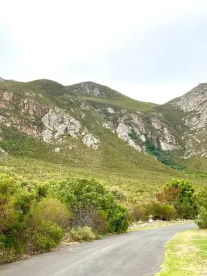 an empty road with mountains in the background at Mountain View Voëlklip One Bedroom in Hermanus