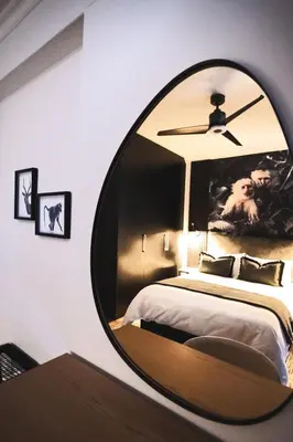 a circular mirror in a bedroom with a bed at The Onyx Stellenbosch in Stellenbosch