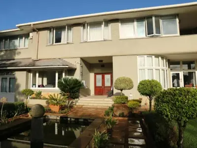 a house with a pond in front of it at The Boston Guest House in Bellville