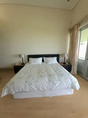 a bedroom with a large white bed with two lamps at Beachfront Golf Estate Escape in Strand in Strand