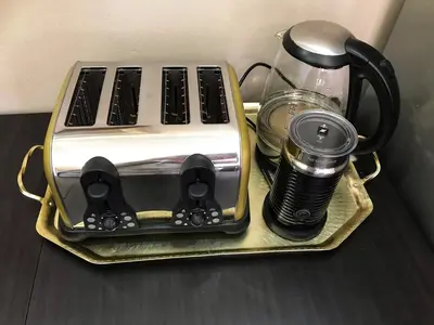 a toaster sitting on a gold tray with a coffee maker at Quiet Business Stay with Stunning Pool in Welgemoed