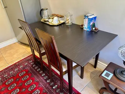 a dining room table with two chairs and a table and a table at Quiet Business Stay with Stunning Pool in Welgemoed