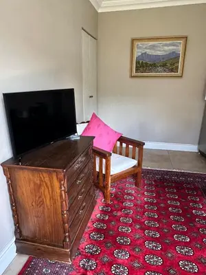 a living room with a flat screen tv and a couch at Quiet Business Stay with Stunning Pool in Welgemoed