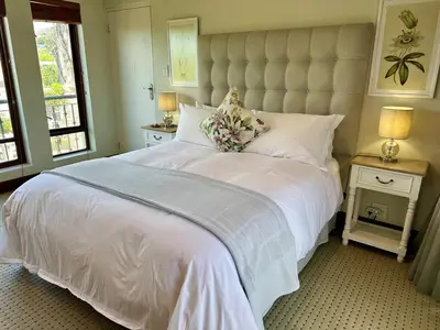 a bedroom with a large white bed and two windows at Quiet Business Stay with Stunning Pool in Welgemoed
