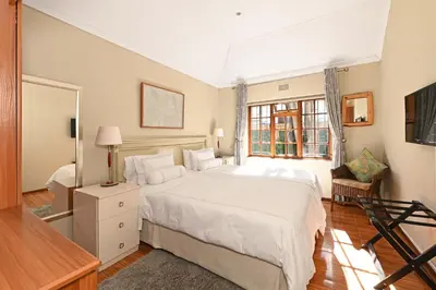 a bedroom with a large white bed and a window at Unique Thatch Home in Champagne area in Pinelands in Cape Town