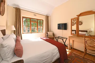 a bedroom with a large white bed and a window at Unique Thatch Home in Champagne area in Pinelands in Cape Town