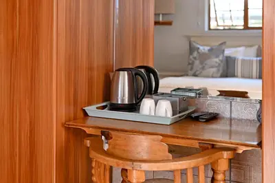 a table with a coffee maker on top of it at Unique Thatch Home in Champagne area in Pinelands in Cape Town