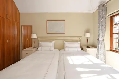 a bedroom with a large bed with two white pillows at Unique Thatch Home in Champagne area in Pinelands in Cape Town