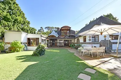 an image of a house with a lawn at Unique Thatch Home in Champagne area in Pinelands in Cape Town