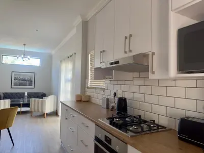 a kitchen with a stove top oven next to a living room at The Hidden Gem in Oakdale