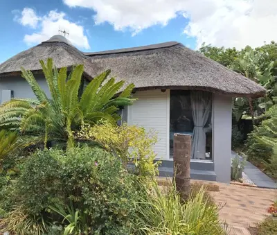 a small cottage with a thatched roof at The Thatched Cottage in Eversdal