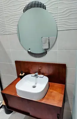 a bathroom with a sink and a mirror at The Thatched Cottage in Eversdal