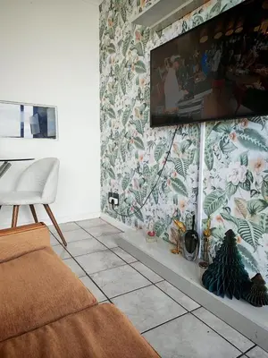 a living room with a tv on a floral wall at Comfy 1 Bedroom Flat in Thornton