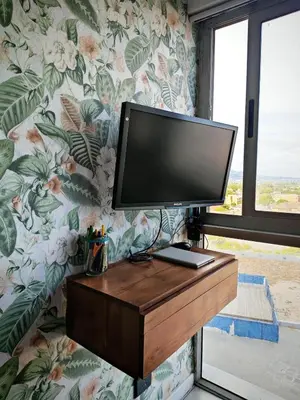a flat screen tv on a wall with floral wallpaper at Comfy 1 Bedroom Flat in Thornton