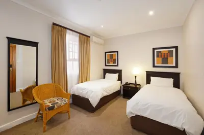 a hotel room with two beds and a mirror at Cumberland Hotel & Conference Centre Worcester in Worcester