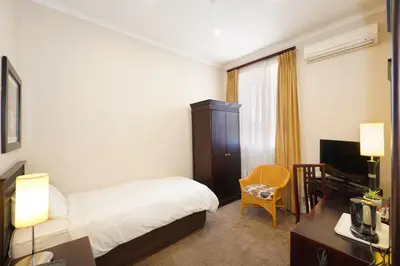 a hotel room with a bed and a desk and a television at Cumberland Hotel & Conference Centre Worcester in Worcester