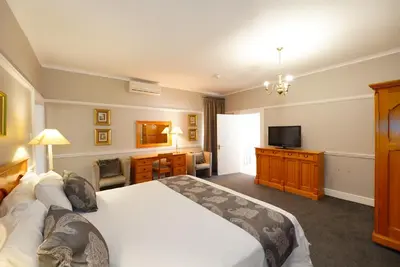 a bedroom with a large bed and a television at Cumberland Hotel & Conference Centre Worcester in Worcester