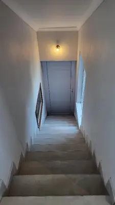 a hallway with stairs and a white door at Frankie's Nest in Cape Town