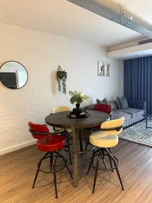 a living room with a table and colorful chairs at Enzo Stay -The Matrix 505 , Century City in Cape Town