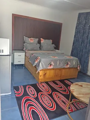 a bedroom with a large bed and a table at One Bed Room Apartment 1A in Cape Town