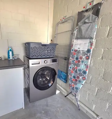 a washing machine in a kitchen next to a brick wall at 2 Bedroom house at Tweespruit - Pet friendly in Stellenbosch