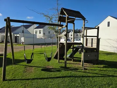 a swing set in a park with grass at 2 Bedroom house at Tweespruit - Pet friendly in Stellenbosch