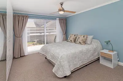 a bedroom with a bed and a window at The Woodbridge Hideaway in Cape Town