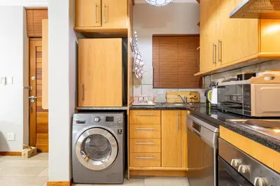 a kitchen with a washer and a washing machine at Avemore Eikehoff no 2 in Stellenbosch