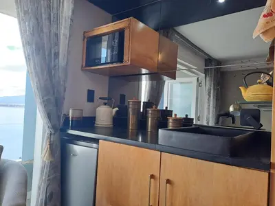 a kitchen with a sink and a microwave at Boutique Inn - Quintessence in Gordonʼs Bay