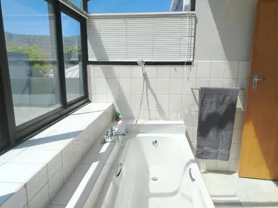 a white bath tub in a bathroom with a window at Art House on Main in Hermanus