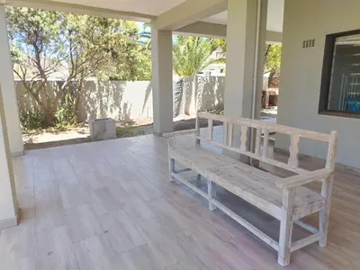 a wooden bench sitting on the porch of a house at Art House on Main in Hermanus