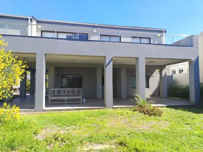 a large white building with a bench in front of it at Art House on Main in Hermanus