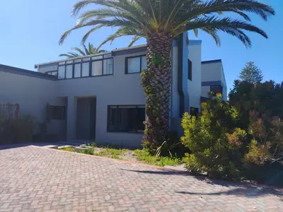 a palm tree in front of a white house at Art House on Main in Hermanus