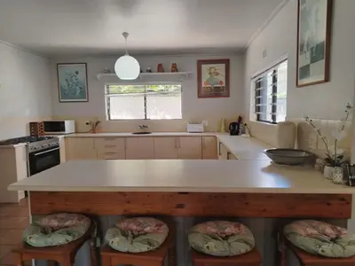a kitchen with a large island with stools at Art House on Main in Hermanus