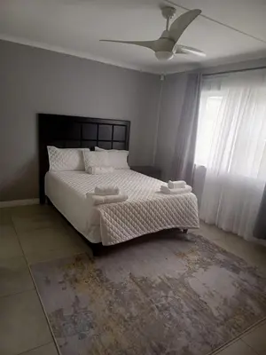 a bedroom with a bed and a ceiling fan at Capetown Adilo Villa in Cape Town