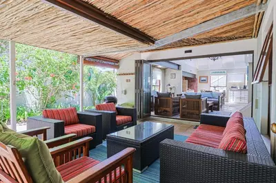 an outdoor living room with couches and a table at Herringbone with Wood-Fired Hot Tub in Hermanus