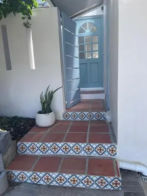 a blue door on a house with a tile walkway at Blou Huis in Hermanus