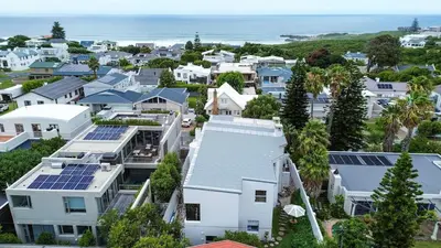 an aerial view of houses with solar panels on their roofs at Blou Huis in Hermanus