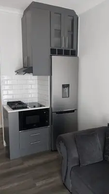 a kitchen with a stove and a refrigerator and a couch at B3 bnb House in Cape Town